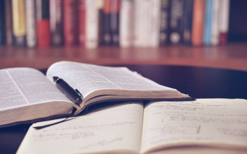 Open books and research papers on library desk