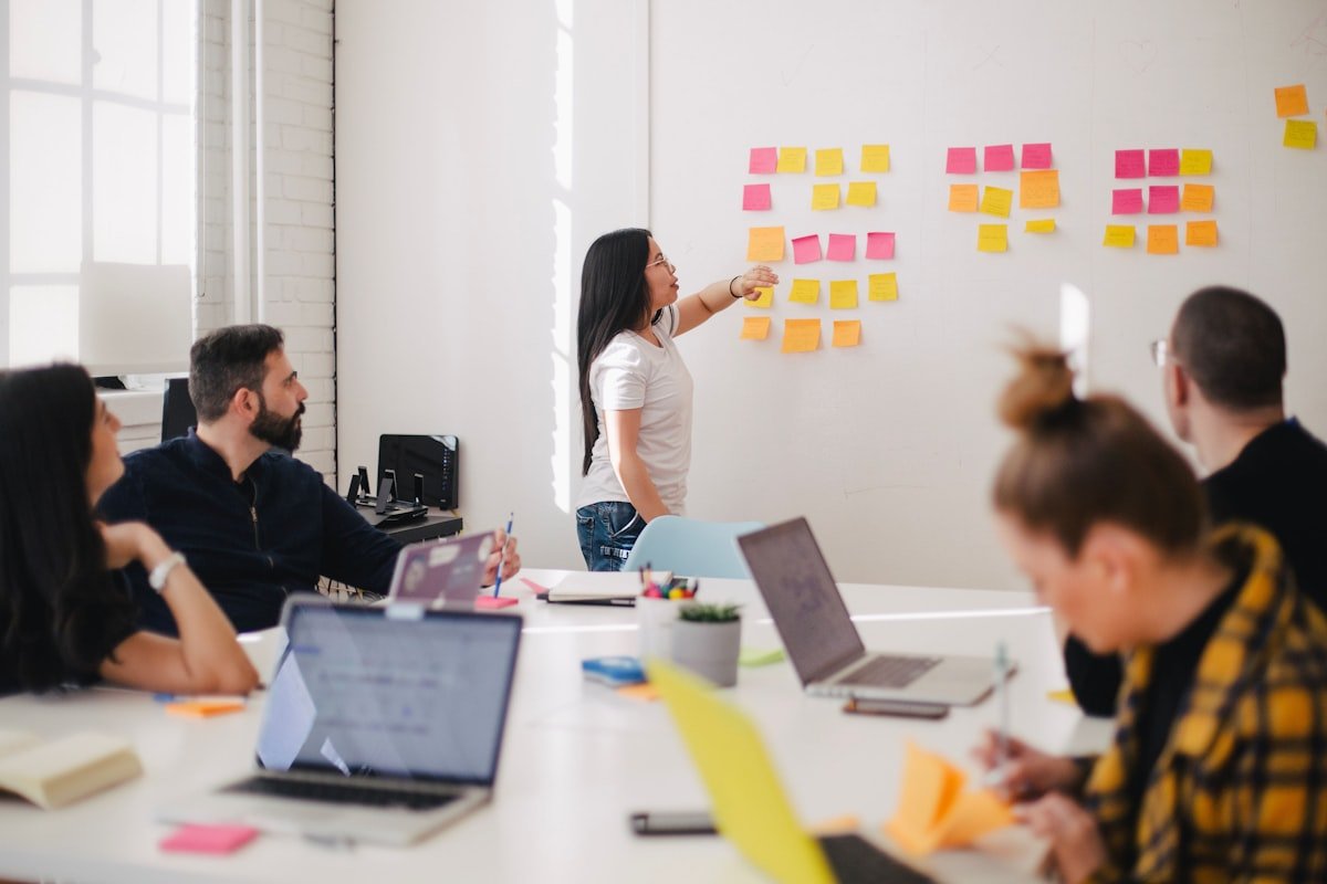 Team meeting in modern office discussing content strategy on whiteboard