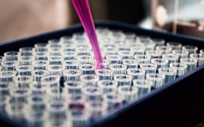 Scientist in lab coat working with molecular research equipment