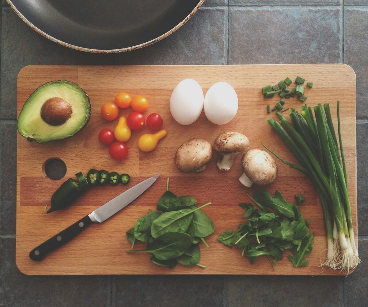 Fresh vegetables and meal prep containers on kitchen counter