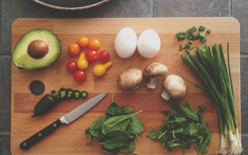 Fresh vegetables and meal prep containers on kitchen counter