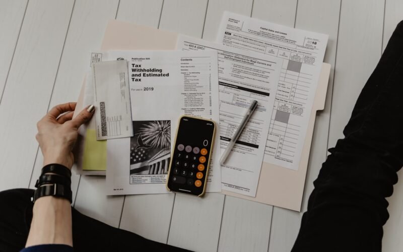 Calculator, coins and financial planning notebook on desk