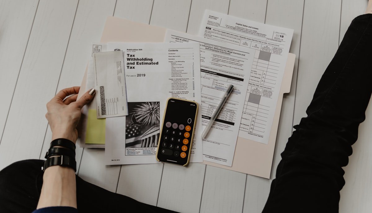 Calculator, coins and financial planning notebook on desk