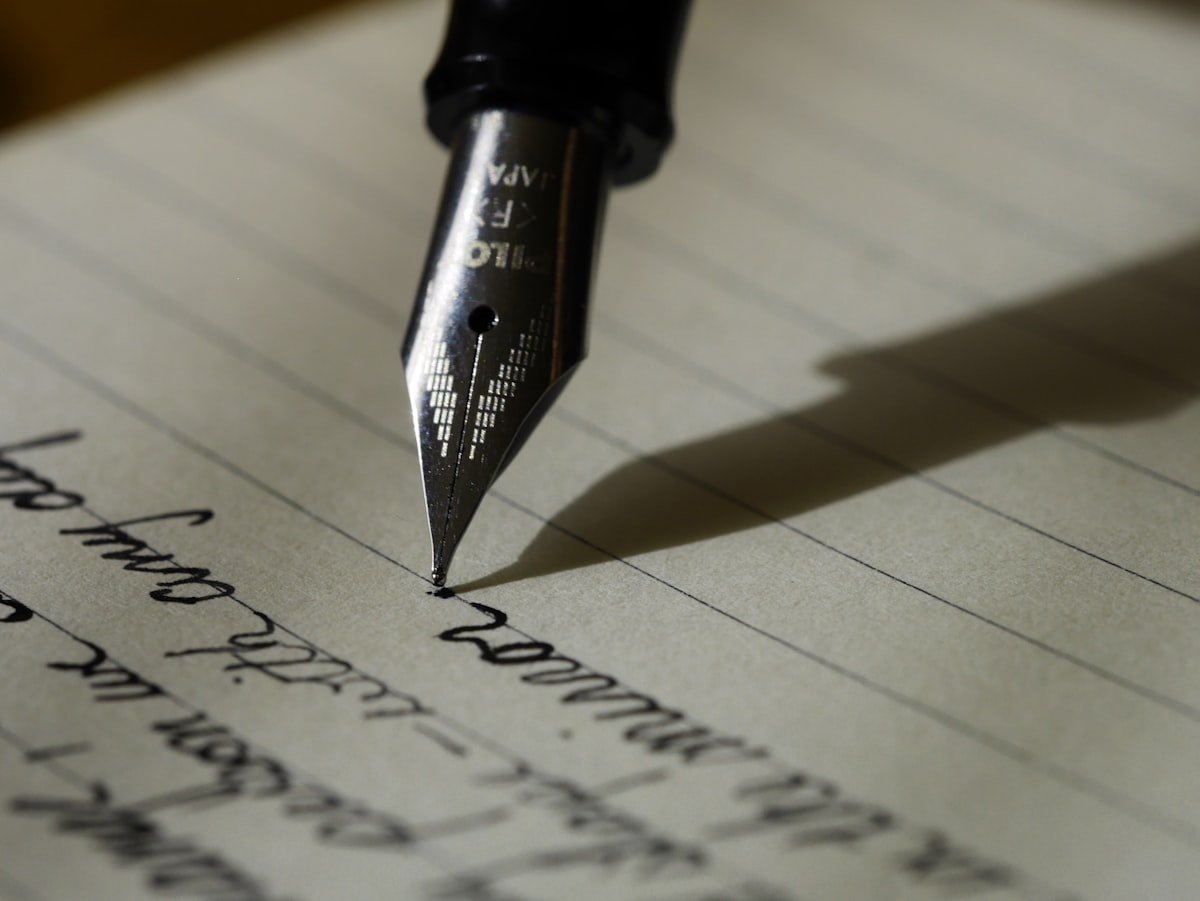 Person writing on laptop at a clean desk workspace